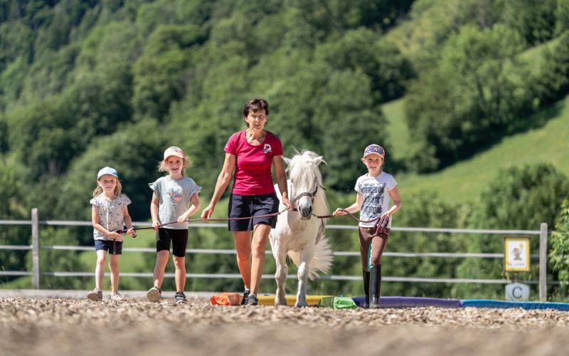 Reitpädagogin Ilona Hutter mit drei Kindern und einem weißen Pony in Dorfgastein